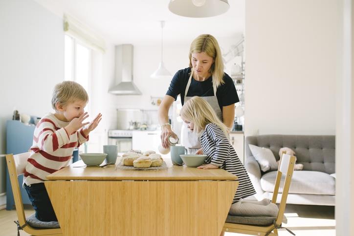 A mother serving breakfast to her kids